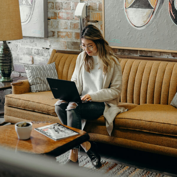Lady sitting on sofa with laptop
