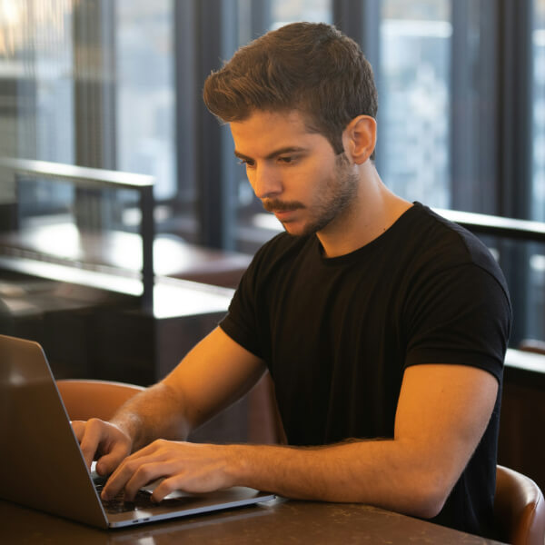 Man in black tshirt working on laptop